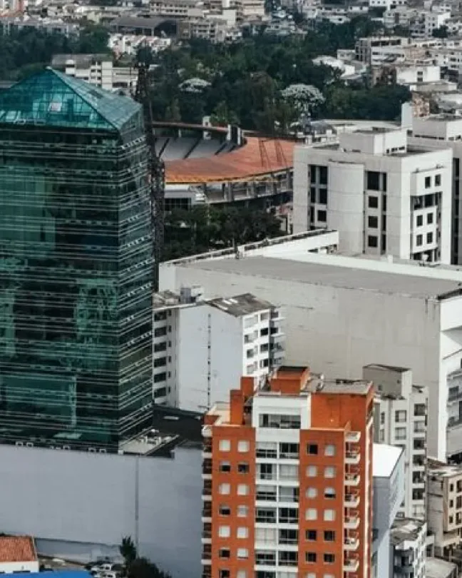 Vista aérea de edificios de una ciudad rodeada de montañas.
