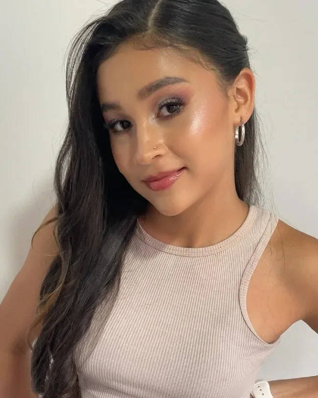Maquillaje social luminoso para grados: piel radiante con iluminador, sombra rosada y labios en tono rosa.
